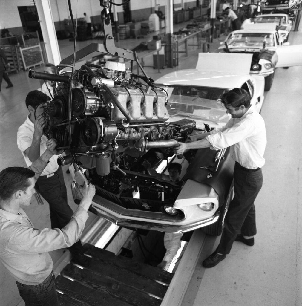 An engine is guided carefully into a Ford Boss 429 Mustang in 1969.