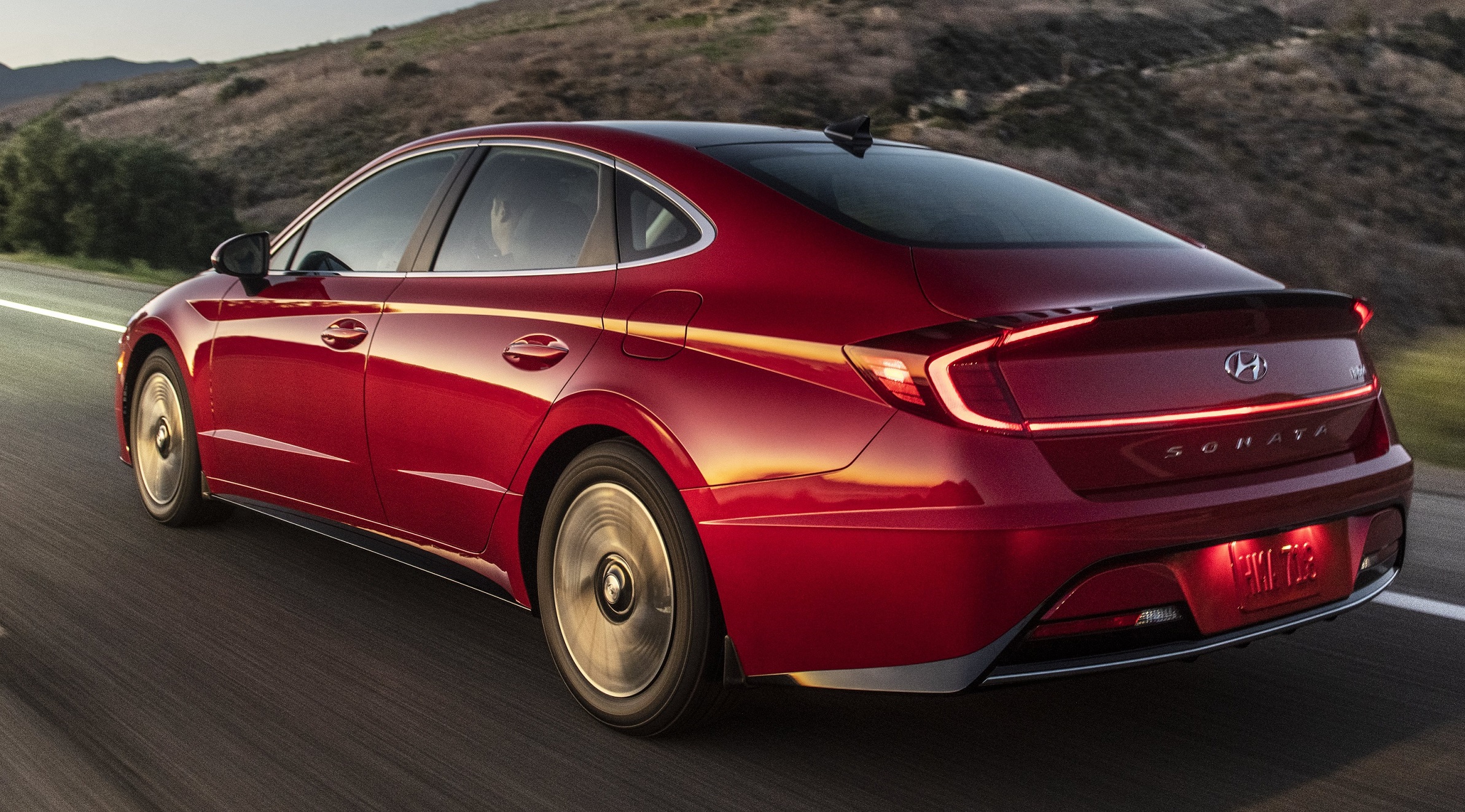 A rear view of the red Sonata that shows the lighted taillights
