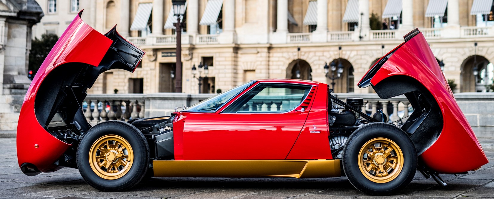 The Rosso Corsa Lamborghini Miura SV with front and rear hoods open.