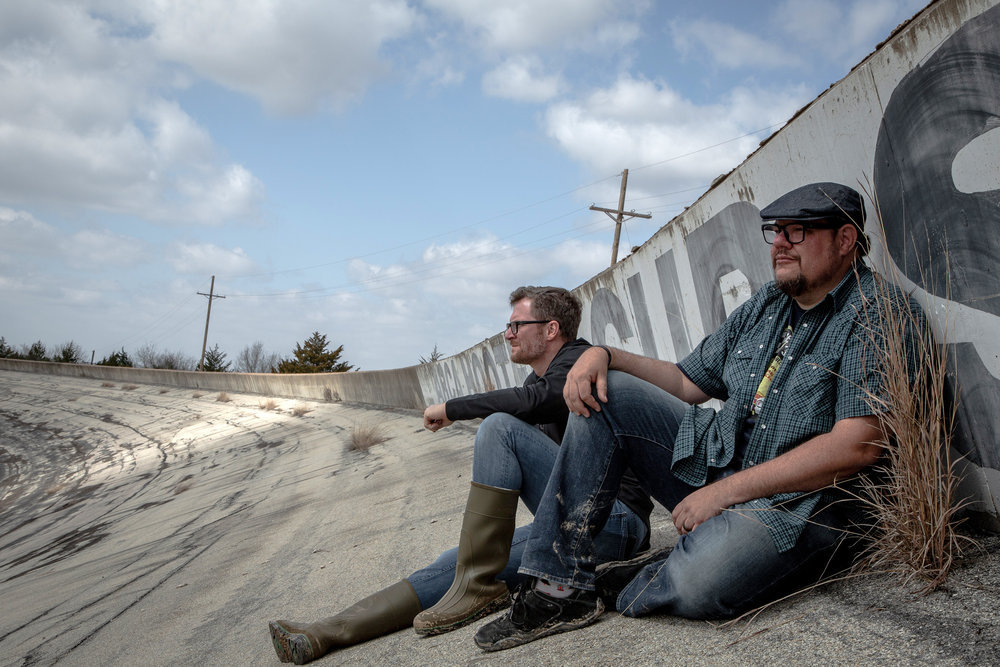 Dale Earnhardt Jr. and Matthew Dillner sit along a banked portion of the Texas World Speedway, 