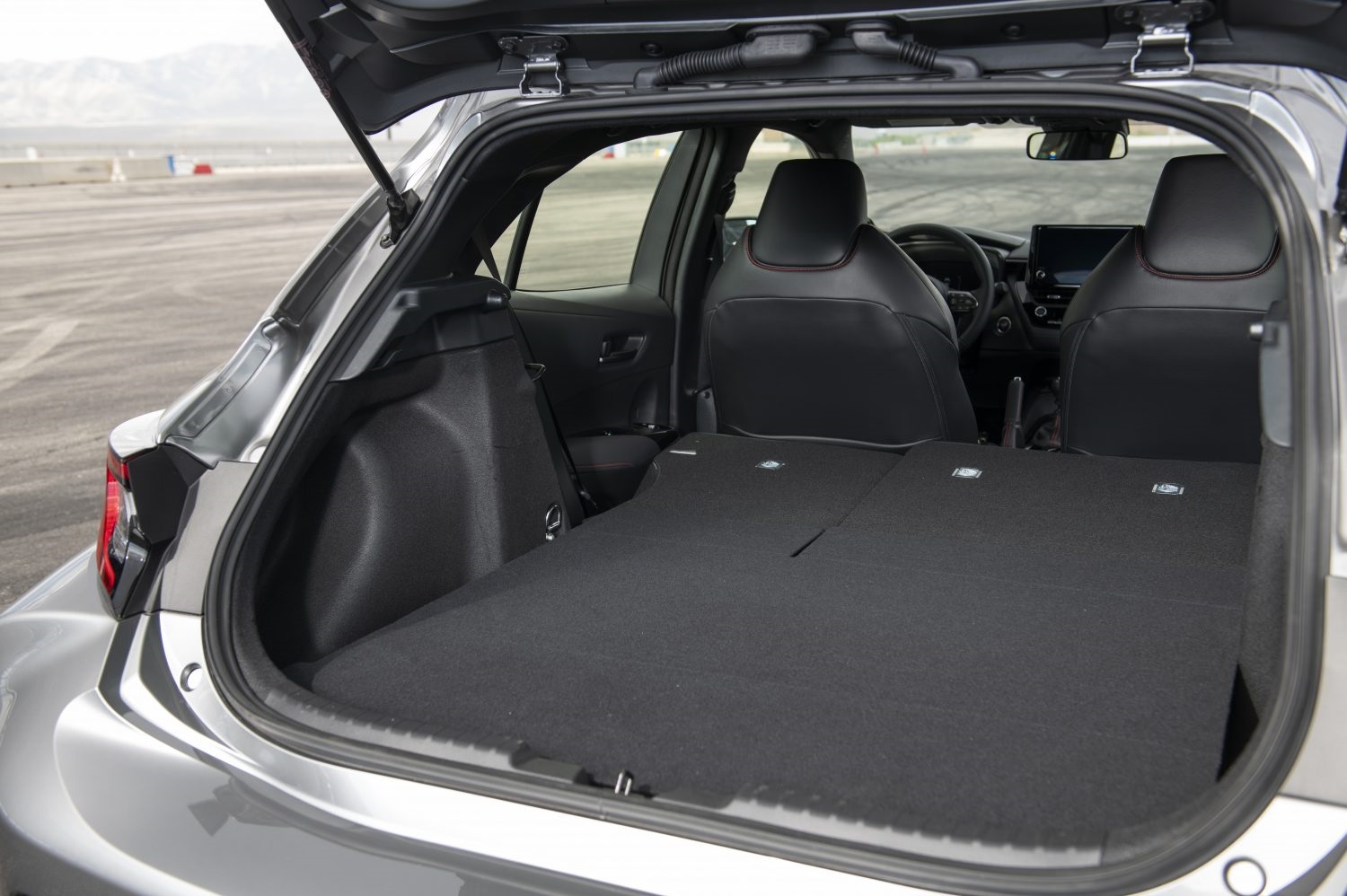 The open cargo door shows plenty of space for groceries and track gear