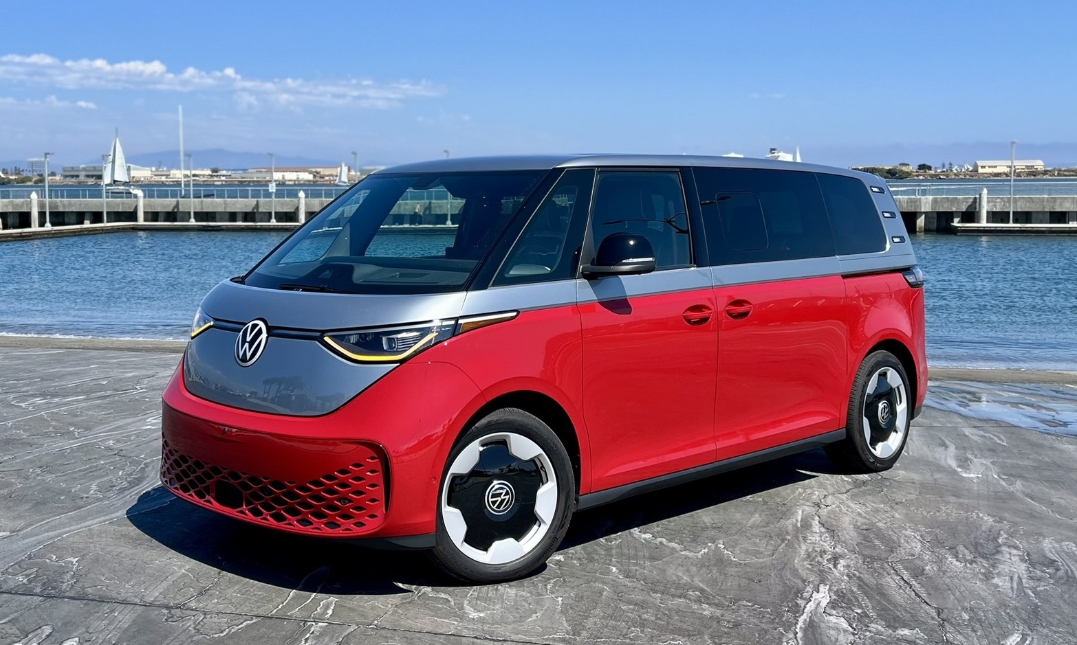 A two tone silver upper and red lower VW ID Buzz along a shelter island boat launch in San Diego