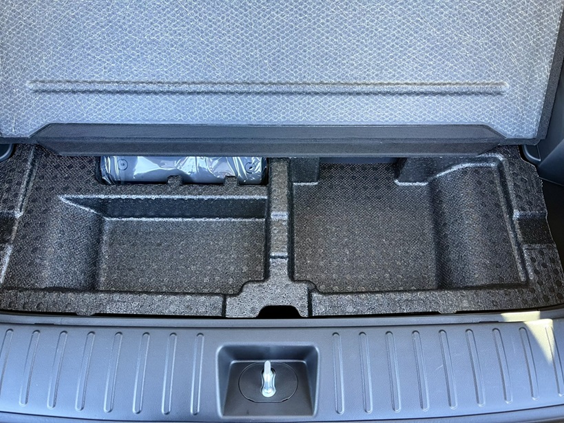 Looking at he space under the cargo floor where the spare tire inflation system is stored until needed