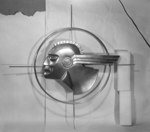 A black and white studio view of Pontiac’s Indian head emblem.