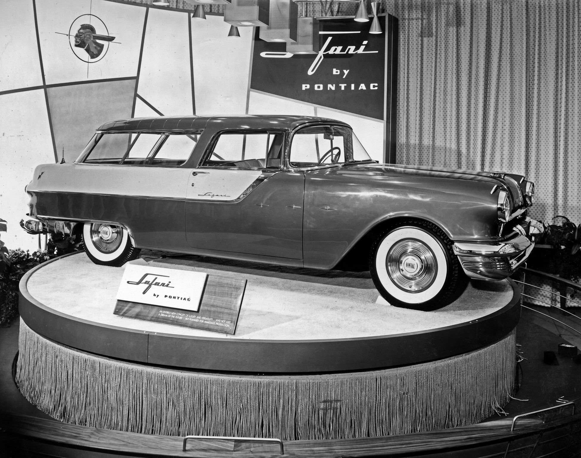A black and white from a 1955 auto show showing the new for 1955 Pontiac Safari two door sport wagon