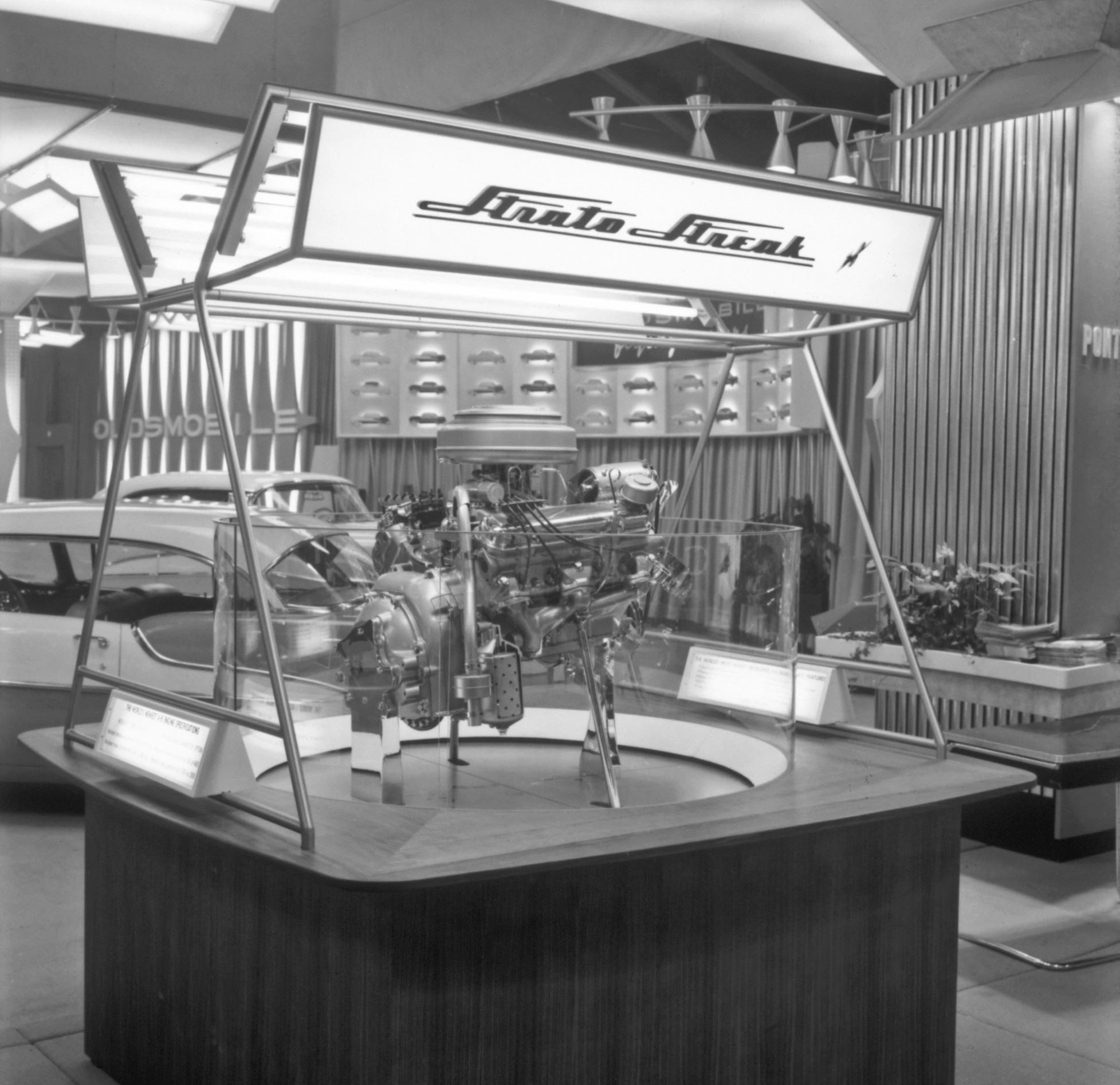 A Black and white 1955 image of a Strato Streak V-8 auto show engine display.