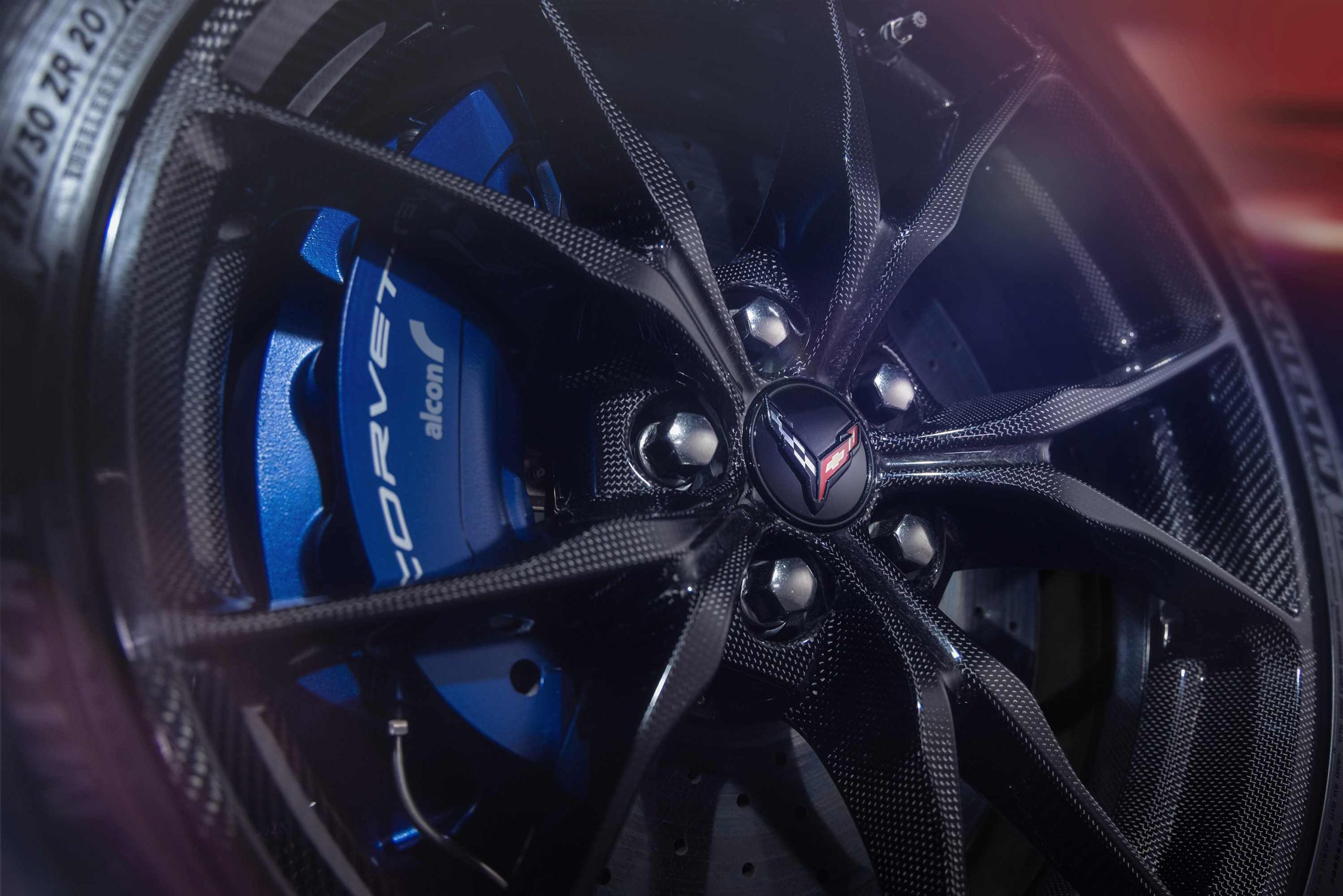 Looking at a close up of a back Corvette wheel with a blue caliper