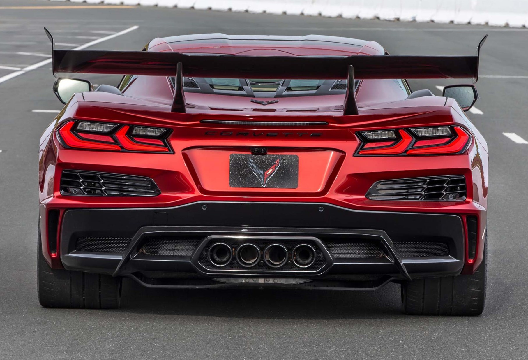 Looking at the rear end of a Torch Red ZR1X with quad black exhaust tips