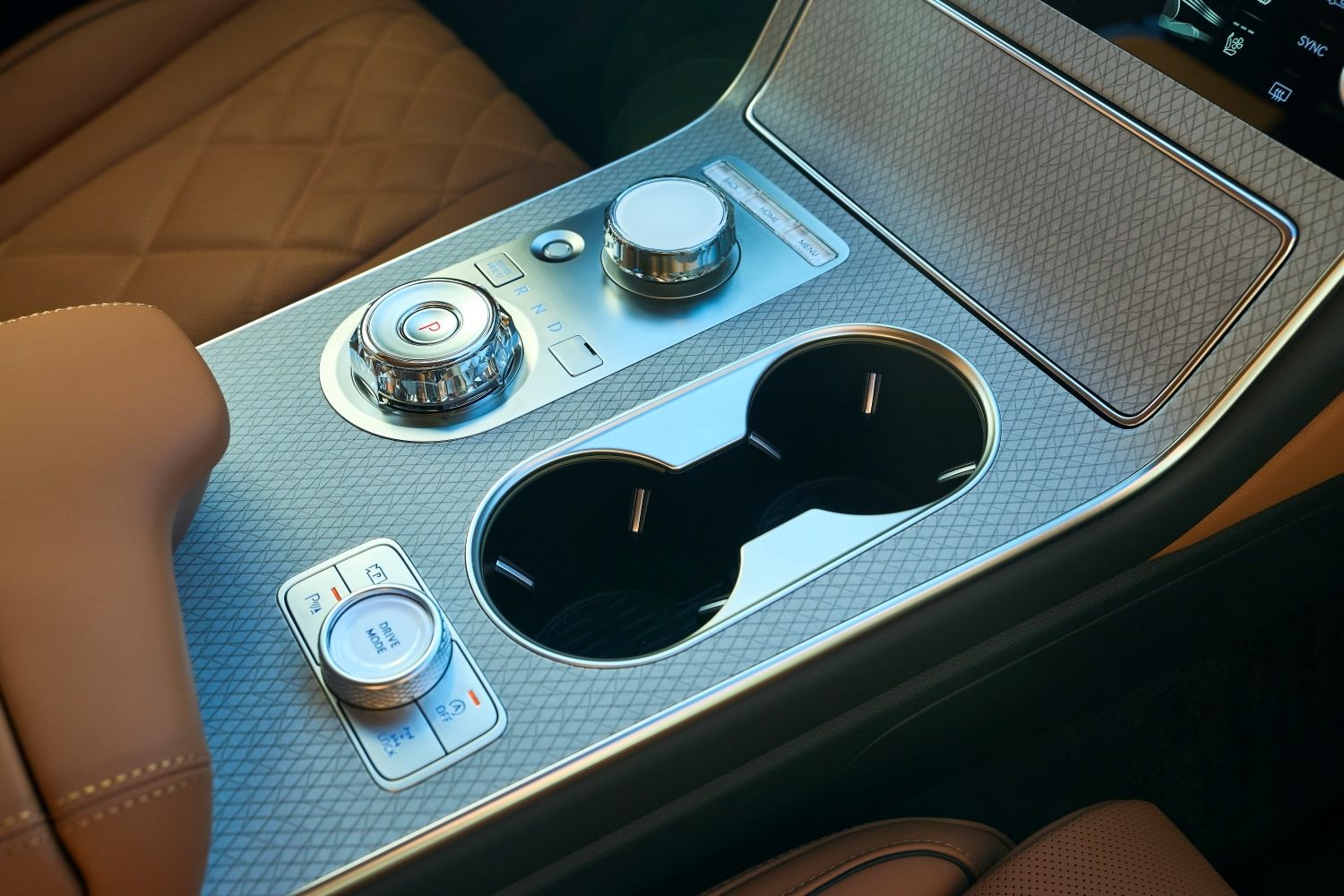 Looking at the center console with shifter dial and infotainment dial, with 2 cup holders