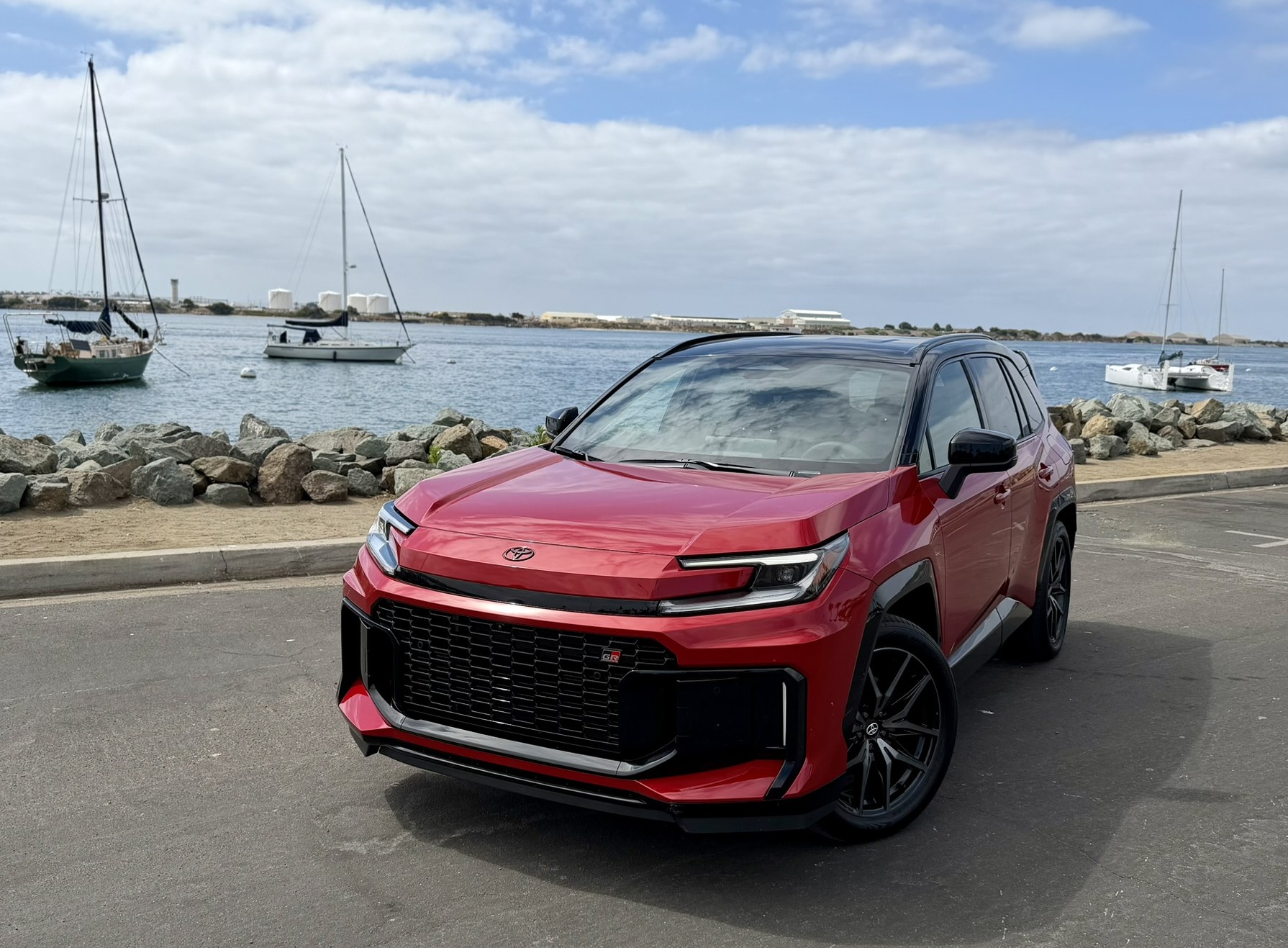 A two tone red and black RAV4 GR Sport is photographed next to the Shelter Island marine